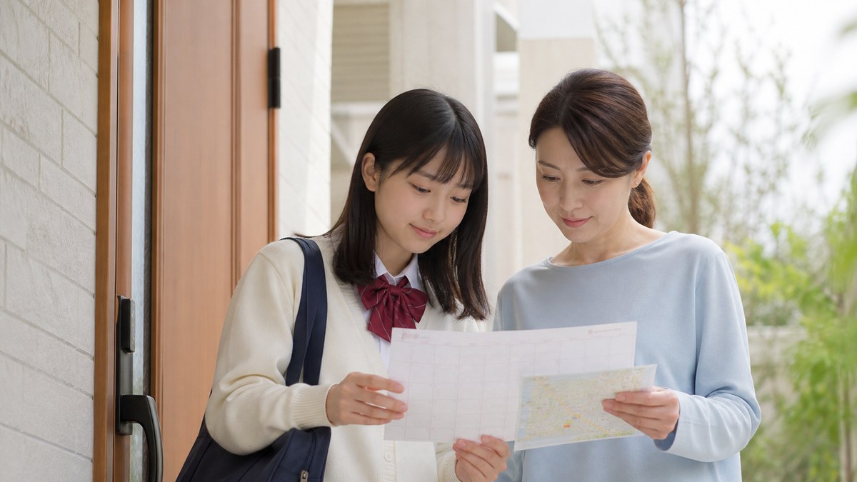 日数と場所を確認してスクーリングへ備える日本人の親子