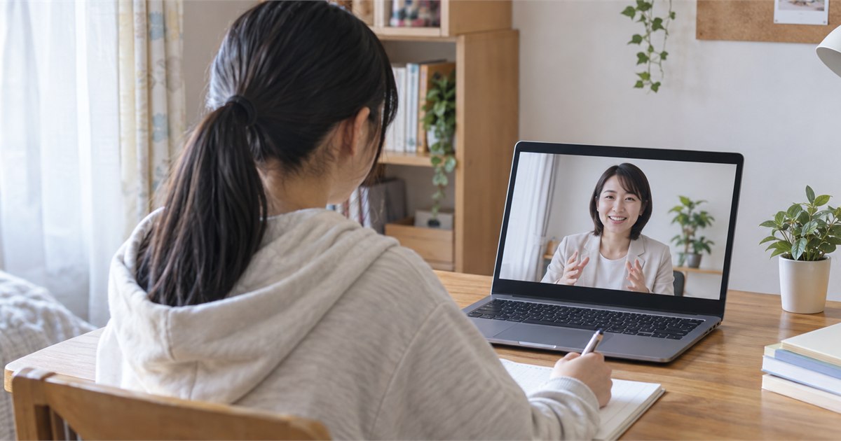 自宅のパソコンを通じて日本人担当者から学校説明を受ける高校生