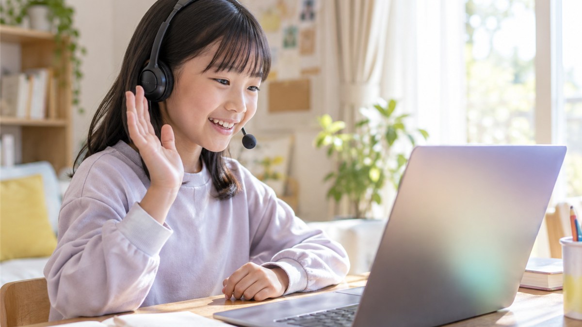 明るい自室で画面越しの相手と交流する日本人の小学生